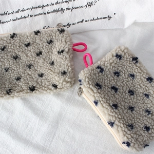 Close-up of soft plush texture on white storage bags with blue dots and pink zipper pulls