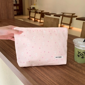 Close-up of pink floral makeup bag with cute rabbit and strawberry prints and zipper