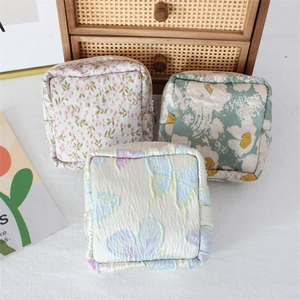 Three elegant jacquard floral organizer bags in pink, teal and blue for toiletries