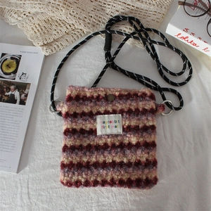 Detail showing plush striped texture and logo patch of the stylish small crossbody bag