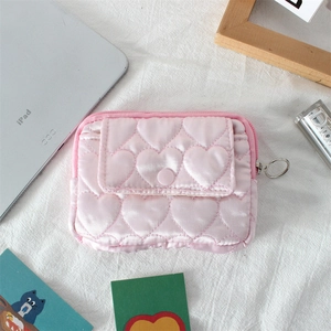 Dettaglio della pochette rosa trapuntata a cuori con tasca a patta e zip argento