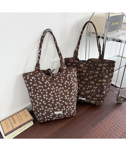 Detail of floral quilted canvas tote bags with Magic Pocket label and shoulder straps
