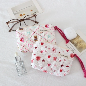 Detailed close-up of quilted cosmetic bags with cute bear and rabbit cartoon patterns