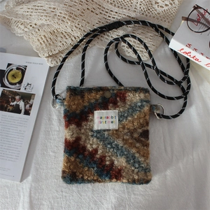 Detail of plush crossbody bag featuring geometric print and rope shoulder strap