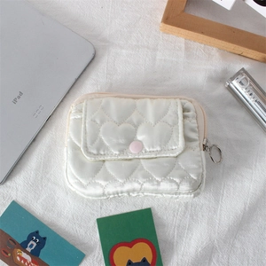 Dettaglio della mini borsa trapuntata a cuore con bottone a pressione rosa e cerniera