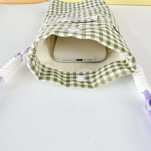 Close-up of green checkered phone bag showing beige lining and secure resin snap button
