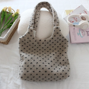 Close-up of plush fleece tote bag with black polka dot pattern in a cozy setting