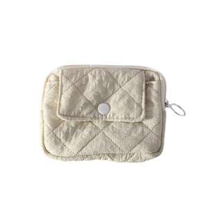 Quilted mini coin purse in cream white fabric with a snap flap and circular metal zipper pull