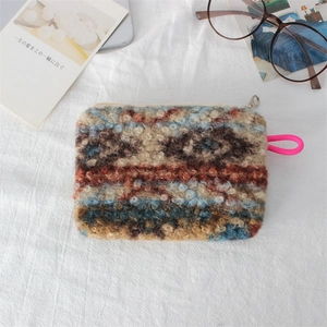 Close-up of vintage jacquard plush makeup bag with colorful patterns and pink rope handle