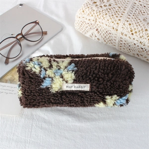 Macro shot of soft brown plush flower pencil case with May Rabbit label on fabric