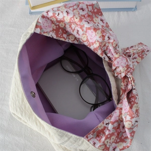 Quilted floral handbag with bow accent showing interior capacity and lavender lining
