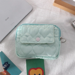 Dettaglio della pochette trapuntata a cuore azzurra con cerniera ad anello e bottone a scatto