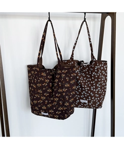 Close-up of quilted floral tote bags featuring Magic pocket woven labels and cotton texture