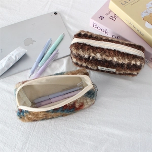 Detail of plush pencil cases with zipper and May Rabbit label on a cozy desk setup