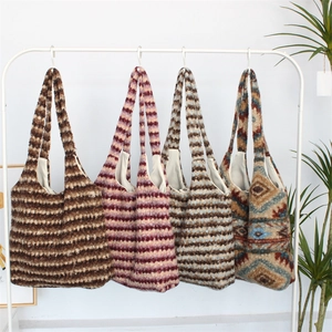 Hanging display of four colorful knit tote bags with ethnic patterns and plush texture