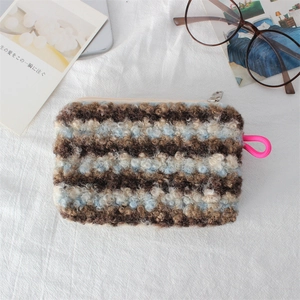 Close-up of curly plush makeup bag with colorful stripes and silver zipper detail