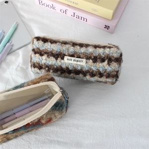 Macro detail of plush striped pencil case featuring a zipper and MAY RABBIT fabric label