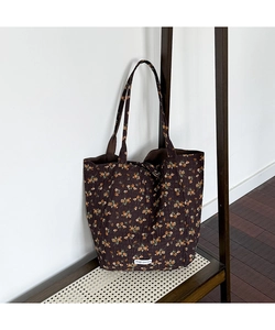 Detail view of floral tote bag featuring dark coffee fabric with orange flower pattern