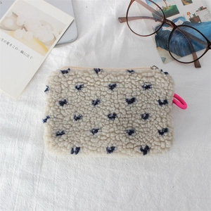 Detail of soft sherpa makeup bag with blue heart pattern and pink zipper puller