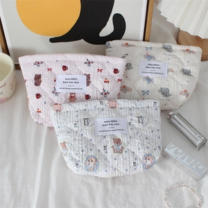 Detailed view of three quilted cotton cosmetic bags with bear and elephant floral patterns