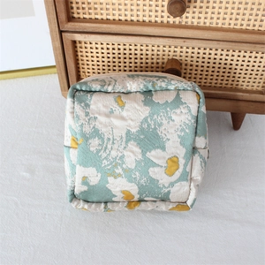 Floral makeup pouch with pastel flowers and zipper detail on a rustic background