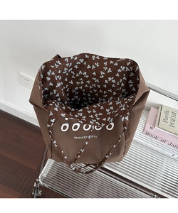 Detail of vintage brown canvas tote bag featuring floral lining and letter printing