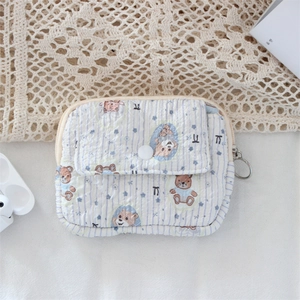 Close-up of quilted cartoon bear coin purse with blue stripes and flap card pocket