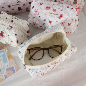 Detail of quilted cosmetic bags with cute cartoon patterns and soft fabric texture