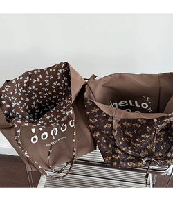 Detailed close-up of reversible floral tote bag with printed text and cotton linen texture