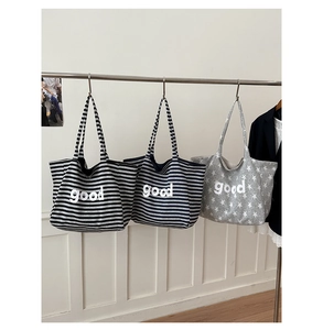 Three striped canvas tote bags with good lettering hanging for a detail display