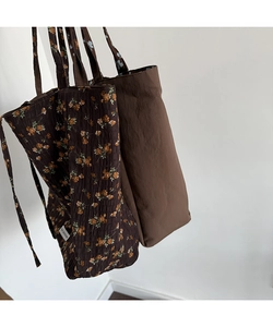 Detail of floral and solid brown tote bags showing fabric texture and thin shoulder straps