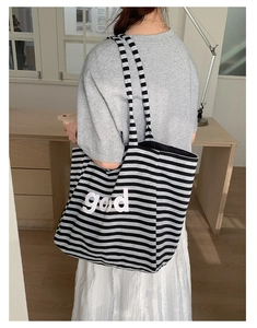 Detail of striped canvas tote bag with good lettering and durable woven texture