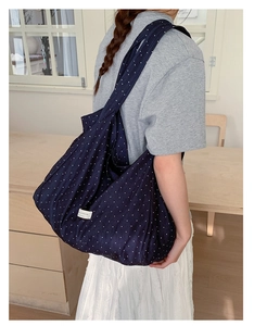 Detail of navy blue polka dot canvas tote bag showing large capacity and brand label