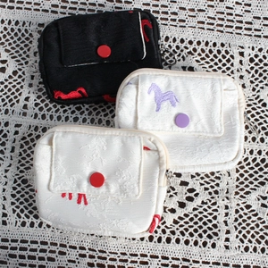Detailed top view of embroidered fabric coin purses with pony patterns on lace background