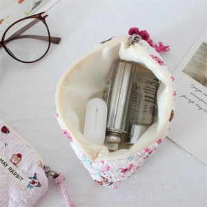 Close-up of floral quilted cosmetic bag with soft padding for lipsticks and gadgets