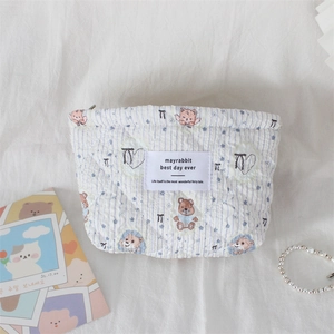 Detailed view of quilted makeup bag with cute bear patterns and blue stripes