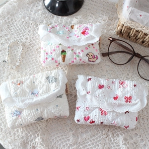 Close-up of quilted floral coin purses with delicate lace trim and snap button closure