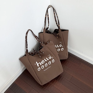 Brown canvas tote bag with floral lining and white lettering for daily commuting