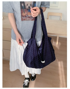 Detail of navy blue polka dot canvas tote bag with wide shoulder straps for daily use