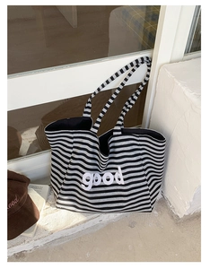 Macro shot of striped canvas tote bag with good letter print on stone stairs