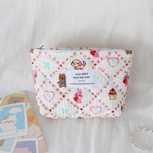Detail of quilted floral cosmetic bag featuring cute cartoon rabbit and bear patterns