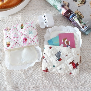 Quilted floral and cartoon dog mini coin purses for earbuds on a white lace cloth
