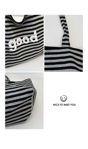 Detail view of striped canvas tote showing high-quality stitching and good letter print