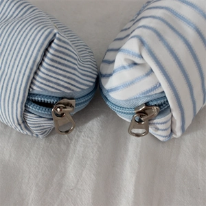 Detailed macro view of blue and white striped fabric bags with metal zipper closure