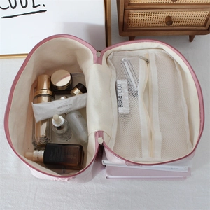 Pink jacquard cosmetic bag with mesh pocket interior for spacious travel storage