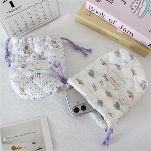 Detail of quilted drawstring storage bags with cartoon bear and elephant patterns