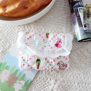 Close-up of quilted floral coin purse with lace trim and cute rabbit patterns