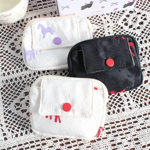 Close-up of embroidered fabric coin purses with traditional horse patterns and snap closure