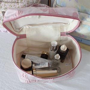Pink jacquard cosmetic bag with butterfly embroidery featuring internal mesh pocket