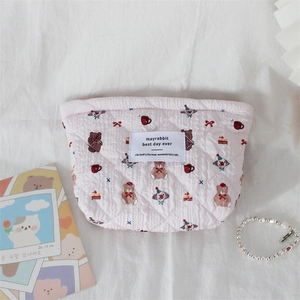 Detail of pink quilted makeup bag with cute cartoon bear and circus patterns